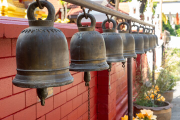 Fototapeta premium Thai Buddhist Temple wat prayer bells in a row in Chiang Mai Thailand for spiritual acts and tourist destination.