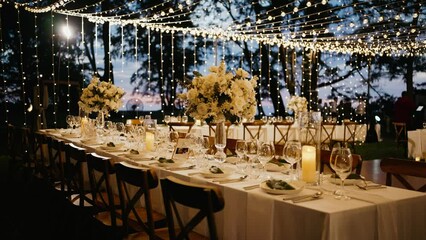 Dinner table setup sunset background. Close up decoration flowers candles Boho style. Romantic wedding reception party outdoor.