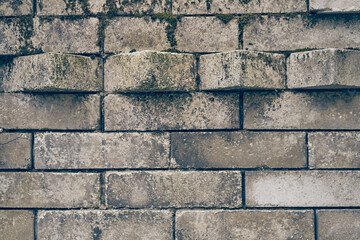 The uneven surface is made of old and dirty stone bricks. The protruding part of the blocks from the wall. An old weathered brick. Stone texture with space to copy. High quality photo