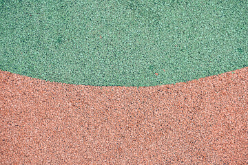 Green and orange rubber coating for playgrounds. EPDM rubber granules. Covering for sports and...
