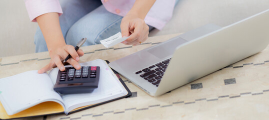 Closeup hands of woman calculating finance household with calculator on desk at home, girl checking...