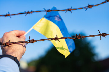 Ukrainian flag and barbed wire. Ban on leaving the country. Law violation