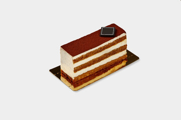 Slice of traditional Italian tiramisu cake on white backdrop