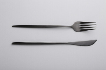 Stylish cutlery on grey table, top view