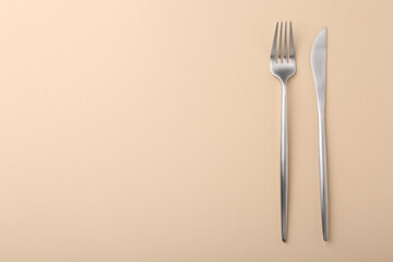 Stylish cutlery on beige table, top view. Space for text