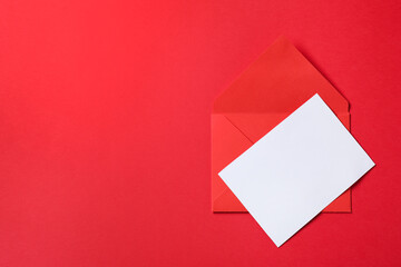 Letter envelope and card on red background, top view. Space for text