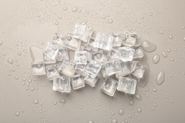 Pile of melting ice cubes and water drops on light grey background, flat lay