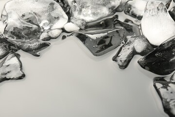 Pieces of crushed ice on grey background, space for text
