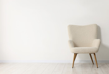 Fototapeta premium Comfortable armchair near white wall in room, space for text