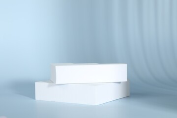 Presentation of product. White podiums on light blue background. Space for text