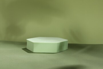 Presentation of product. Podium and shadows on light green background. Space for text