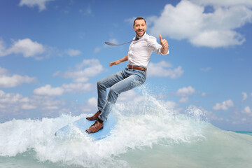 Happy businessman riding a surfboard on a sea wave
