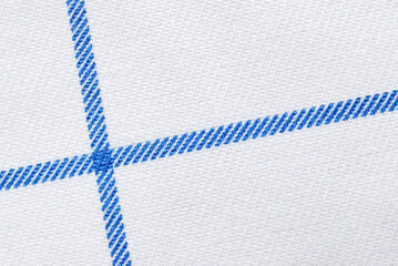 White cotton twill fabric pattern close up with blue crossed lines as background