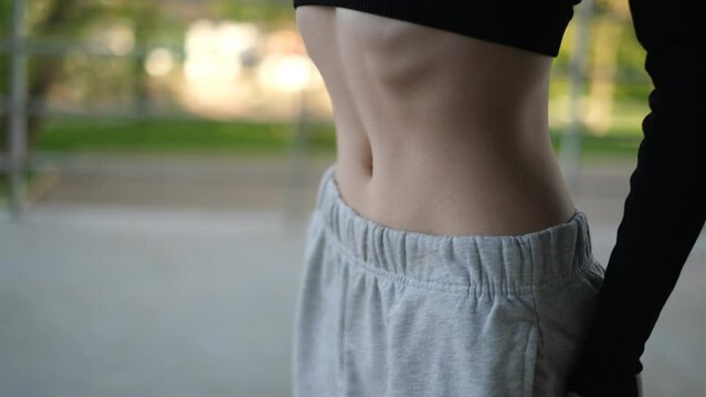Young woman doing breathing exercises vacuum closeup belly