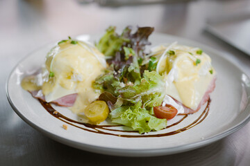 Egg benedict sandwiches in white plate. - muffin with poached egg, ham