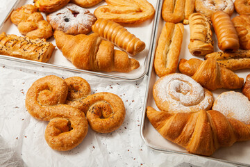 Collection of cakes and different pies with cheese, apple, cherry, meat and cabbage on a plate.