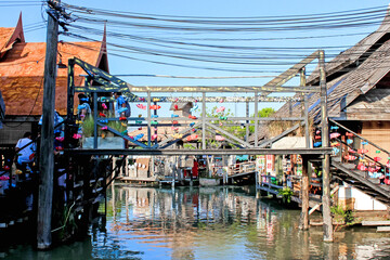 A traditional canal market with a wooden bridge, charming shops, lanterns, and cultural vibrancy