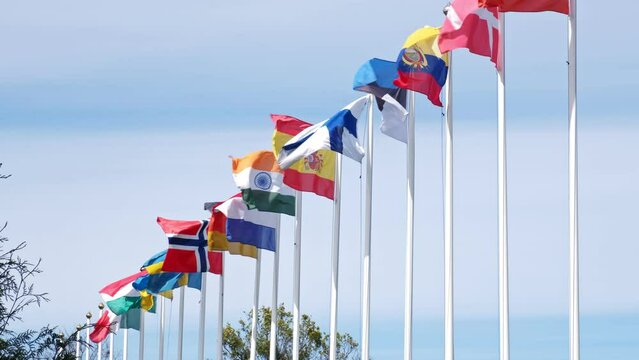 Row of Flagposts with National Flags Waving in the Wind during Official Meeting Conference or Sport Event