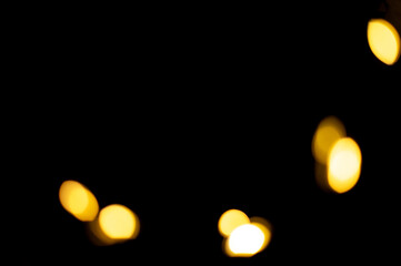 Golden blurred bokeh lights on black background. Christmas lights overlay.