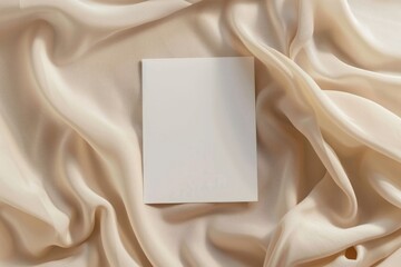 Mockup of white A5 card over beige fabric, in soft light, minimalist aesthetic template,