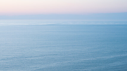 A breathtaking blue and pink sunset over the sea creates