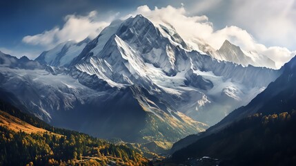 Majestic snow-capped mountain peak with clouds and autumn foliage in the valley.