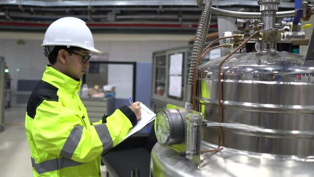 A Factory Engineer Checking Liquid Helium Levels in Storage Tanks, Ensuring Safety Compliance and Recording Usage for Machinery Operations in the Facility