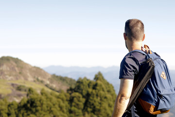 Naklejka premium A man with a backpack looking at the mountains.