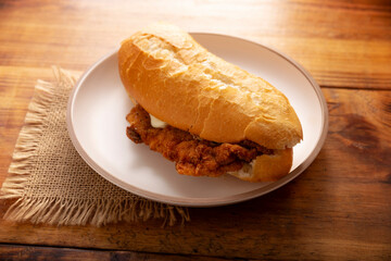 Mexican Torta de Milanesa. Sandwich made with bolillo bread, telera or baguette, split in half and filled with various ingredients, in this case breaded chicken meat with Oaxaca cheese.