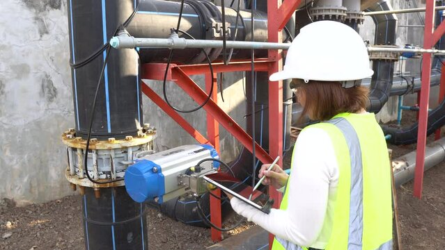 A female engineer working at a water treatment plant, inspecting and maintaining the water supply system, checking chlorine levels, ensuring water quality, and overseeing the dynamo motors and control