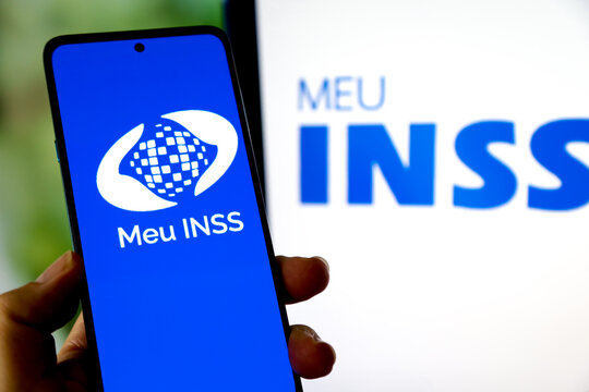 Aplicativo INSS do governo para aposentados no Brasil, na tela de um celular e fundo desfocado.