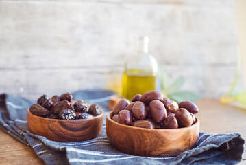 Olives in wooden bowl and olive oil