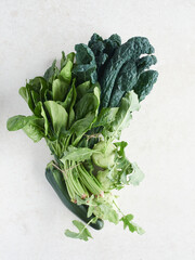 arrangement of fresh leafy greens and vegetables on the countertop. Spinach, kale, kohlrabi and zucchini.