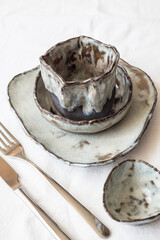 A set of cutlery and tableware on a linen tablecloth. Serving option. Light background, top view.