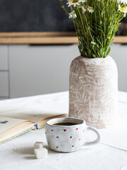 Morning coffee. There is a book on the table, mug of coffee.