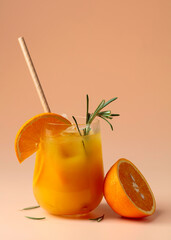Summer cocktail with orange, rosemary, and ice in a frozen glass.