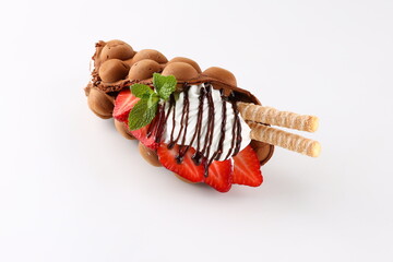 Hong kong or bubble waffle with ice cream, chocolate, marshmallows and strawberries isolated on...