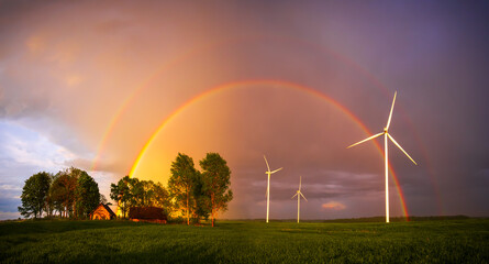 Double rainbow over wind turbines in rural setting focusing on nature and renewable energy