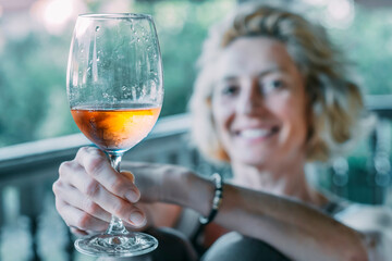A woman is holding a wine glass and smiling