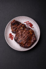 Delicious juicy beef ribeye steak grilled with salt, spices and herbs
