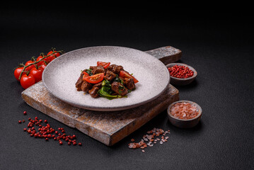 Delicious warm salad with pieces of meat, spinach, tomatoes, salt, spices and herbs