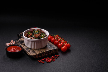 Delicious warm salad with pieces of meat, spinach, tomatoes, salt, spices and herbs