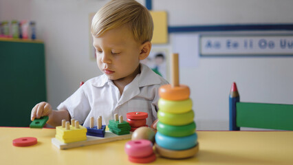 Kid boy playing with wood toys at pre school classroom. Kindergarten education smart games for children