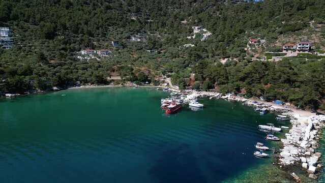 Aerial view of the bay of Golden Beach on Thassos with ships and boats moored onto the harbor