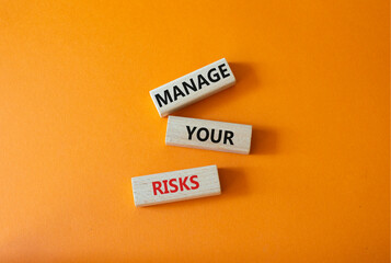 Manage your Risks symbol. Concept words Manage your Risks on wooden blocks. Beautiful orange...