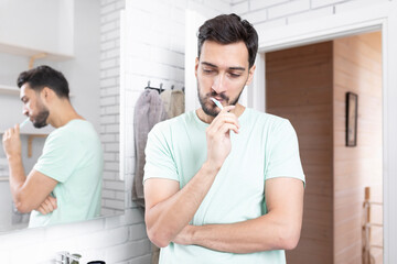 Handsome man brushing teeth in the bathroom	