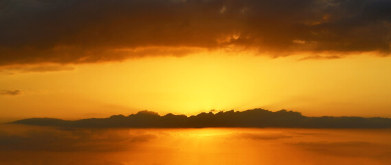 Orange yellow golden sky sunset with fluffy cloud. Beautiful summer nature sky sunlight in the evening. 
