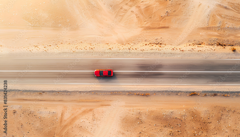 Wall mural car moves along an asphalt road in the desert top view