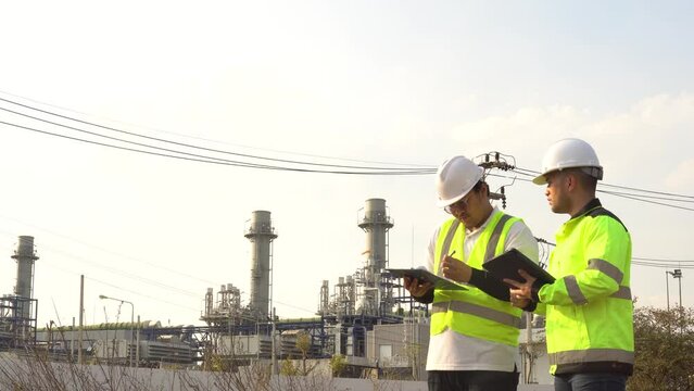 Two engineers working at an industrial plant,power generation facility,discussing operational issues,collaboration between manager and electrical engineer,solving technical problems,ensuring efficient