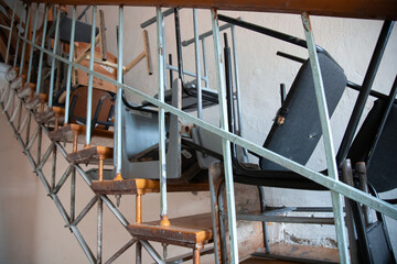 Pile of stacked vintage armchairs.  Side view of multi colored chairs
